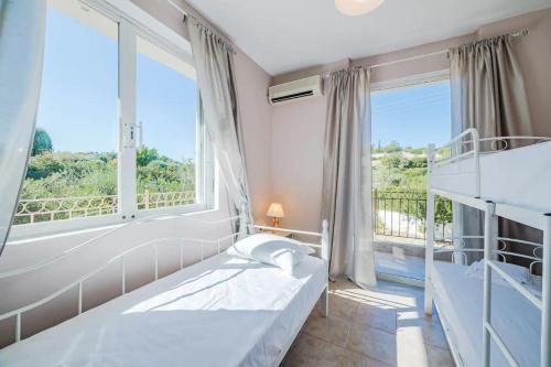 1 dormitorio con 2 camas y ventana grande en J&K HOUSE SUITES, en Aghia Marina