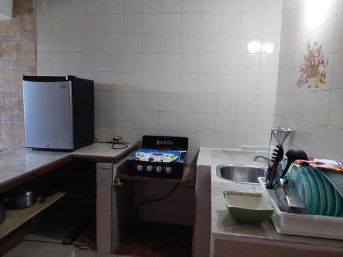 a small kitchen with a sink and a stove at Alojamientos Nazareth in Catia La Mar