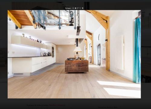 Cette grande chambre dispose d'une cuisine et de parquet. dans l'établissement Loft proche Paris, Charpente apparente, à Pantin