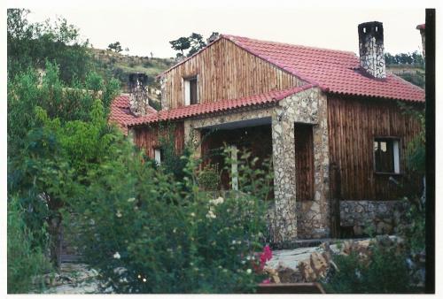 a large wooden house with a red roof at Alojamientos Turisticos La Utrera in Las Majadas