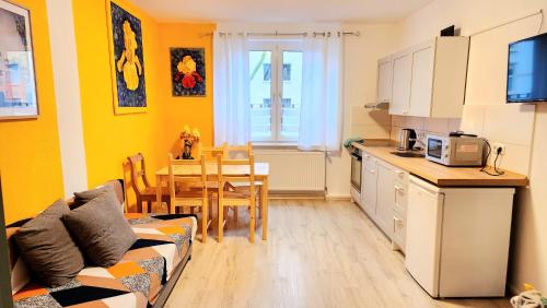 eine Küche und ein Wohnzimmer mit einem Sofa und einem Tisch in der Unterkunft ELENA flat IRIS, Oberhausen Zentrum CentrO Westfield in Oberhausen