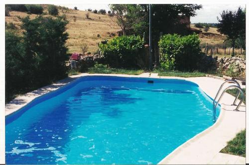 una gran piscina azul en un patio en Alojamientos Turisticos La Utrera en Las Majadas