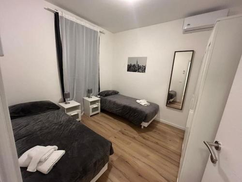 ein Hotelzimmer mit 2 Betten und einem Spiegel in der Unterkunft New House - Garden park bbq in Monfalcone