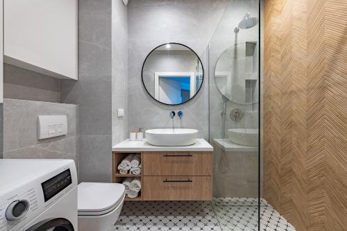 a bathroom with a sink and a mirror at Expo Apartment Kolejowa in Warsaw