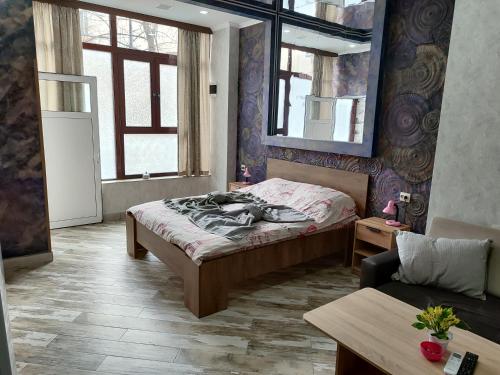 a bedroom with a bed and a couch in it at АРТ 3 in Sliven