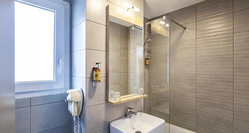 a bathroom with a shower and a toilet and a sink at Ostal Pau Universite - Sure Hotel Collection by Best Western in Pau