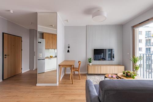a living room with a couch and a table and a kitchen at Expo Apartment Kolejowa in Warsaw