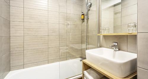 a white bathroom with a sink and a shower at Ostal Pau Universite - Sure Hotel Collection by Best Western in Pau