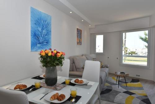 un salon avec une table et deux assiettes de nourriture dans l'établissement AU PORT - BRAND NEW flat w 1 bedroom, balcony, parking, AC, à Antibes
