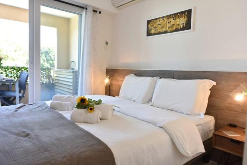 - une chambre avec un grand lit blanc orné de fleurs dans l'établissement AU PORT - BRAND NEW flat w 1 bedroom, balcony, parking, AC, à Antibes