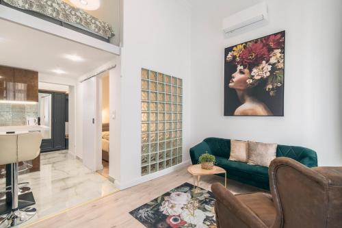 a living room with a green couch and a painting on the wall at CASA GIULIA BUDAPEST in Budapest