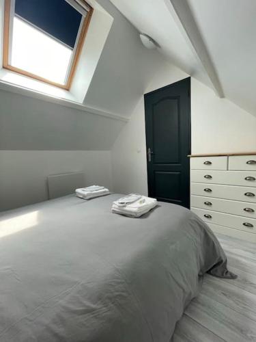 une chambre avec un grand lit et une fenêtre dans l'établissement Maison des Ollivier - Maison Campagne Fécampoise, à Toussaint