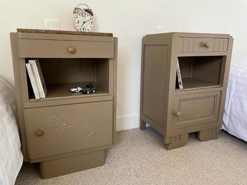 a bedroom with a dresser and a bed with a clock at Fleur & Mer in Montfarville