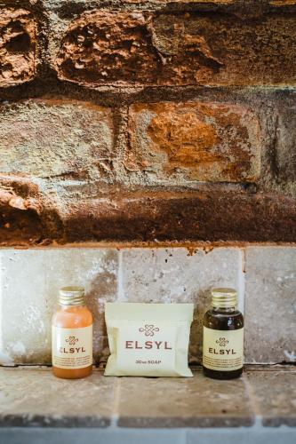 two jars of essential oils sitting next to a brick wall at Mannings Hotel in Truro
