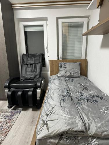 a bedroom with a bed and a chair at Skyline Apartment 2 in Peje