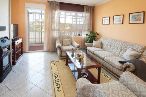 - un salon avec des canapés et une télévision dans l'établissement AG Casa Fuentes Canduas 1, à A Telleira