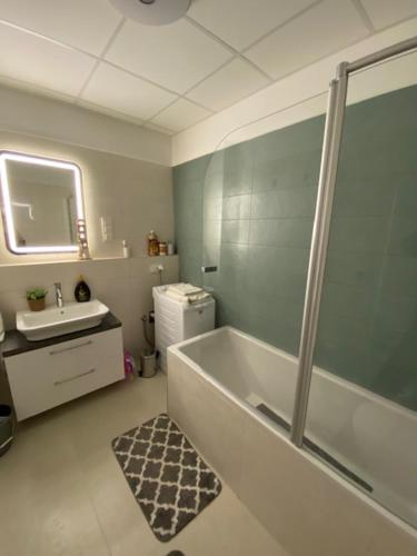 a bathroom with a shower and a tub and a sink at Mistral Residence 408 in Balatonföldvár