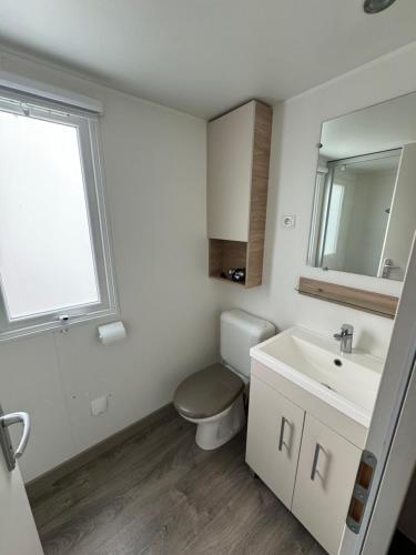 uma casa de banho branca com um WC e um lavatório em MH TIKE - 6p - LES SABLES DU MIDI - VALRAS em Valras-Plage