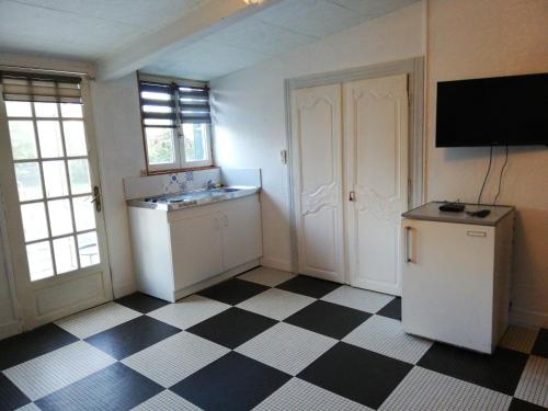 eine Küche mit schwarz-weiß kariertem Boden in der Unterkunft 14 Rue le Menestrel in Dreux