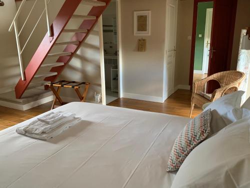 a white bed in a room with a staircase at Fleur & Mer in Montfarville