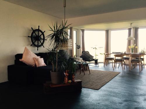 sala de estar con sofá y mesa con sillas en Beltblick, en Fehmarn