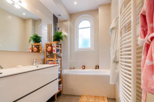 La salle de bains est pourvue d'un lavabo, d'une baignoire et d'une fenêtre. dans l'établissement Appartement en bord de Seine, à Paris