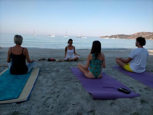a group of people sitting on the beach doing yoga at Beth la Casa della Luna in Annunziata