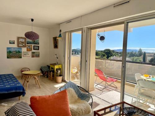 - un salon avec vue sur un balcon dans l'établissement Spacieux appartement au calme à 5 minutes de la mer, parking privé, à Bandol