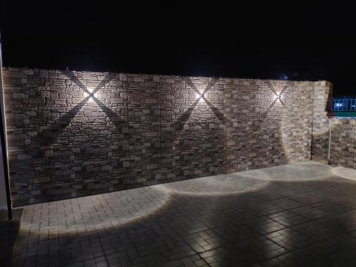 eine Ziegelwand mit Lichtern in der Nacht in der Unterkunft Hotel HV in Nahan