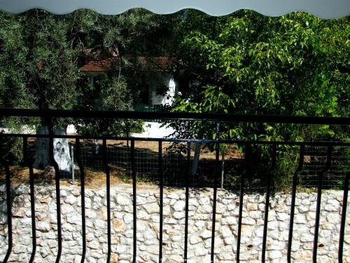 a black fence in front of a yard with trees at Ionio Sea Poros Studios in Mikros Gialos