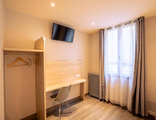 巴黎的住宿－Hotel Aix Europe，一间设有一张桌子和一台墙上的电视的房间