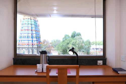 a lamp sitting on a desk in front of a window at Bell Hotel in Sivakāsi