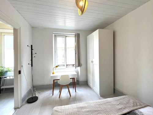 - une chambre avec un bureau, un lit et une fenêtre dans l'établissement Lumière Secrète Mulhouse Centre Parking Tram, à Mulhouse