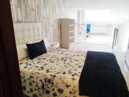 a bedroom with a bed with a blue and white bedspread at LUNA AZUL, Centro Oviedo y con parking in Oviedo