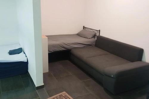 a couch and a bed in a small room at Celine Zimmer in Heilbronn Zentrum in Heilbronn
