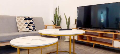 a living room with a tv and a table with two stools at Logan's Transient Home- U1 Apartment with Balcony in Baguio