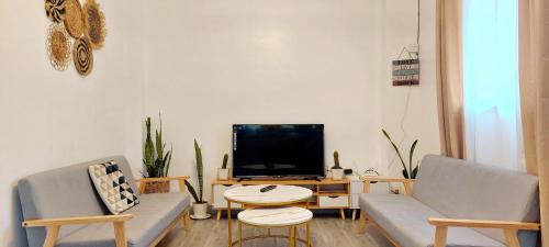 a living room with two chairs and a tv at Logan's Transient Home- U1 Apartment with Balcony in Baguio