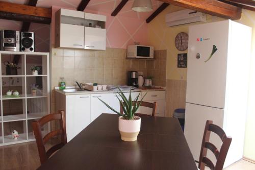 a kitchen with a table and a refrigerator at Apartmani Matija in Opatija