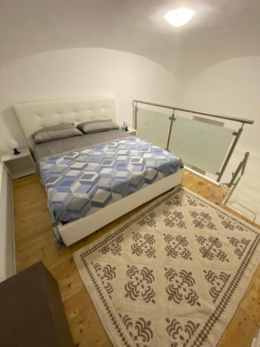 a bedroom with a bed and a rug on the floor at Donna Cuncetta Casa Vacanza Monte di Procida in Monte di Procida
