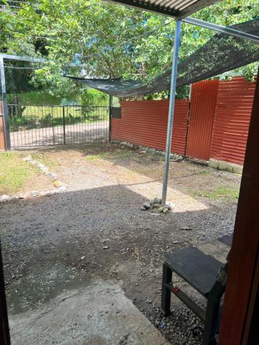 un patio con un banco y una valla roja en Santa Teresa, Montezuma,Tambor,Cobano, en Cóbano