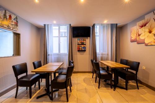 a restaurant with two tables and chairs and a tv at Hotel Aix Europe in Paris