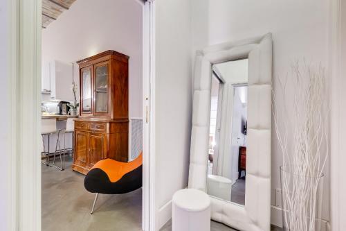 Zimmer mit einem Spiegel, einem Stuhl und einer Küche in der Unterkunft New Suite Barberini Area in Rom