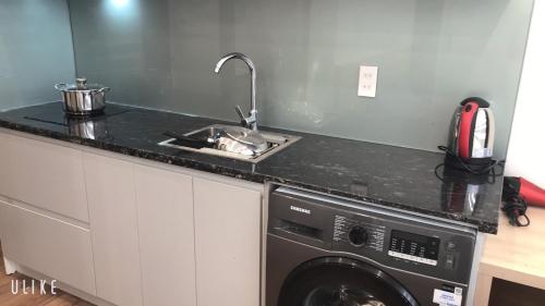 a kitchen with a sink and a washing machine at MinA Apartment - Vinhome Marina Hải Phòng in Hai Phong