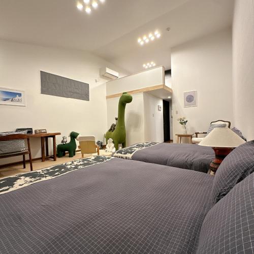 two beds in a bedroom with a dinosaur on the wall at 三米-鶴舞琵琶湖-biwako in Otsu