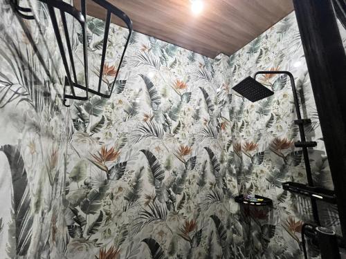 a bathroom with a wall with a floral wallpaper at RRJJ's TRANSIENT - A minute walk away from the beach in Caba