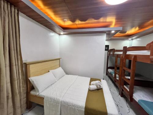 mały pokój z łóżkiem i łóżkiem piętrowym w obiekcie RRJJ's TRANSIENT - A minute walk away from the beach w mieście Caba