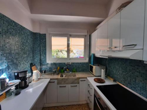 a kitchen with white cabinets and a window in it at Apartment near Acropolis in Athens