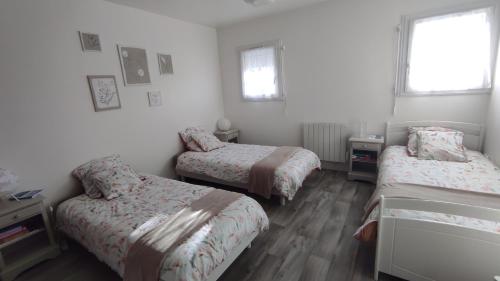 a bedroom with two beds and a window at Les Bordaiseries in La Réorthe