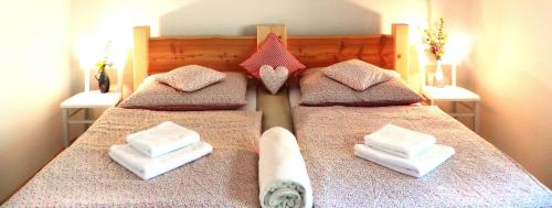 a bedroom with a bed with towels and a bath tub at Penzion Bor in Náchod