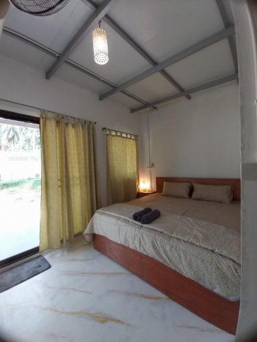 - une chambre avec un lit et une grande fenêtre dans l'établissement AiOonHomestay, à Ban Bang Bao